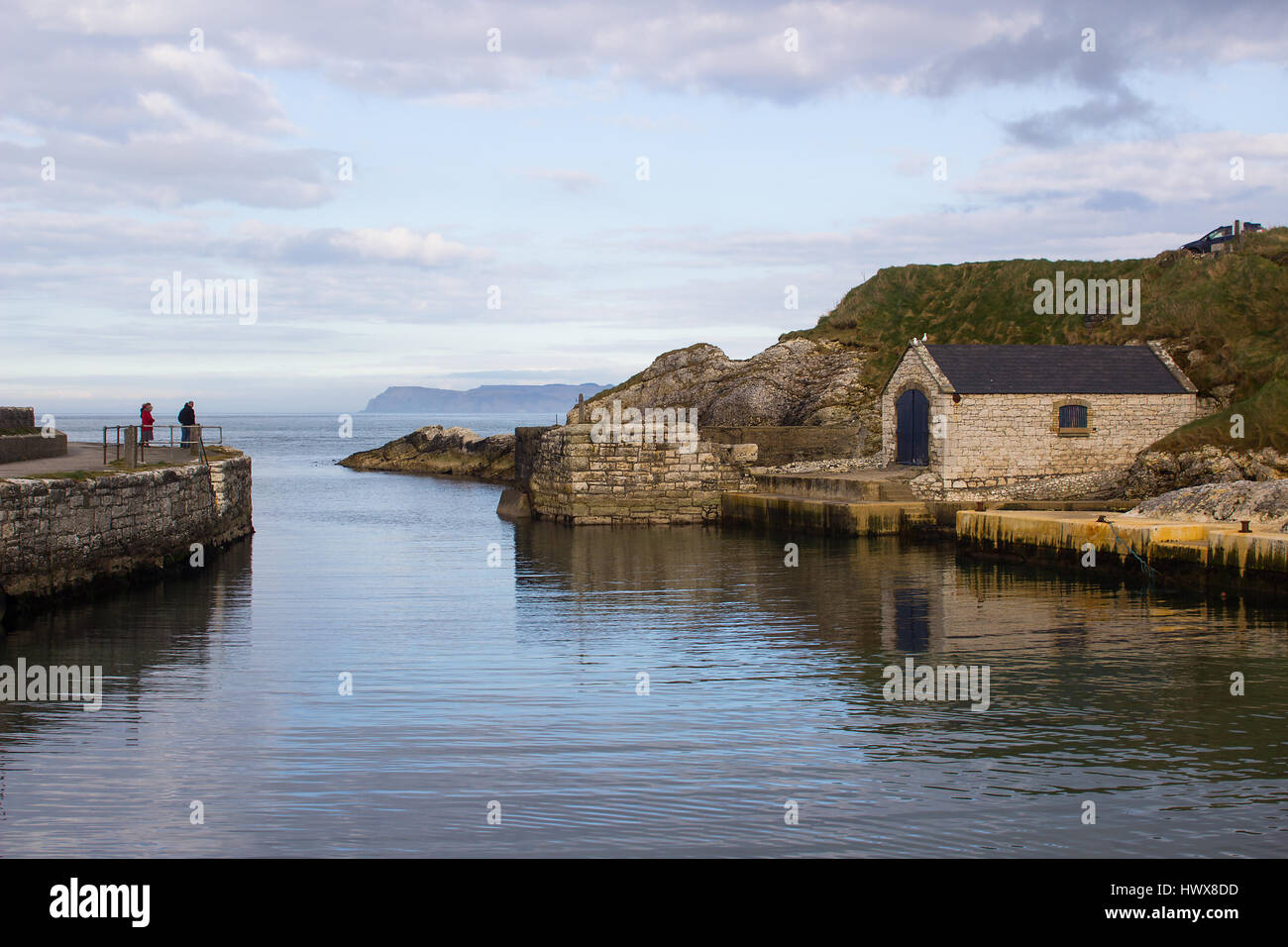 Il Boathouse di piccole dimensioni e di uno scalo a Ballintoy porto sulla costa North Antrim dell Irlanda del Nord con la sua pietra costruito il boathouse in un giorno di primavera Foto Stock