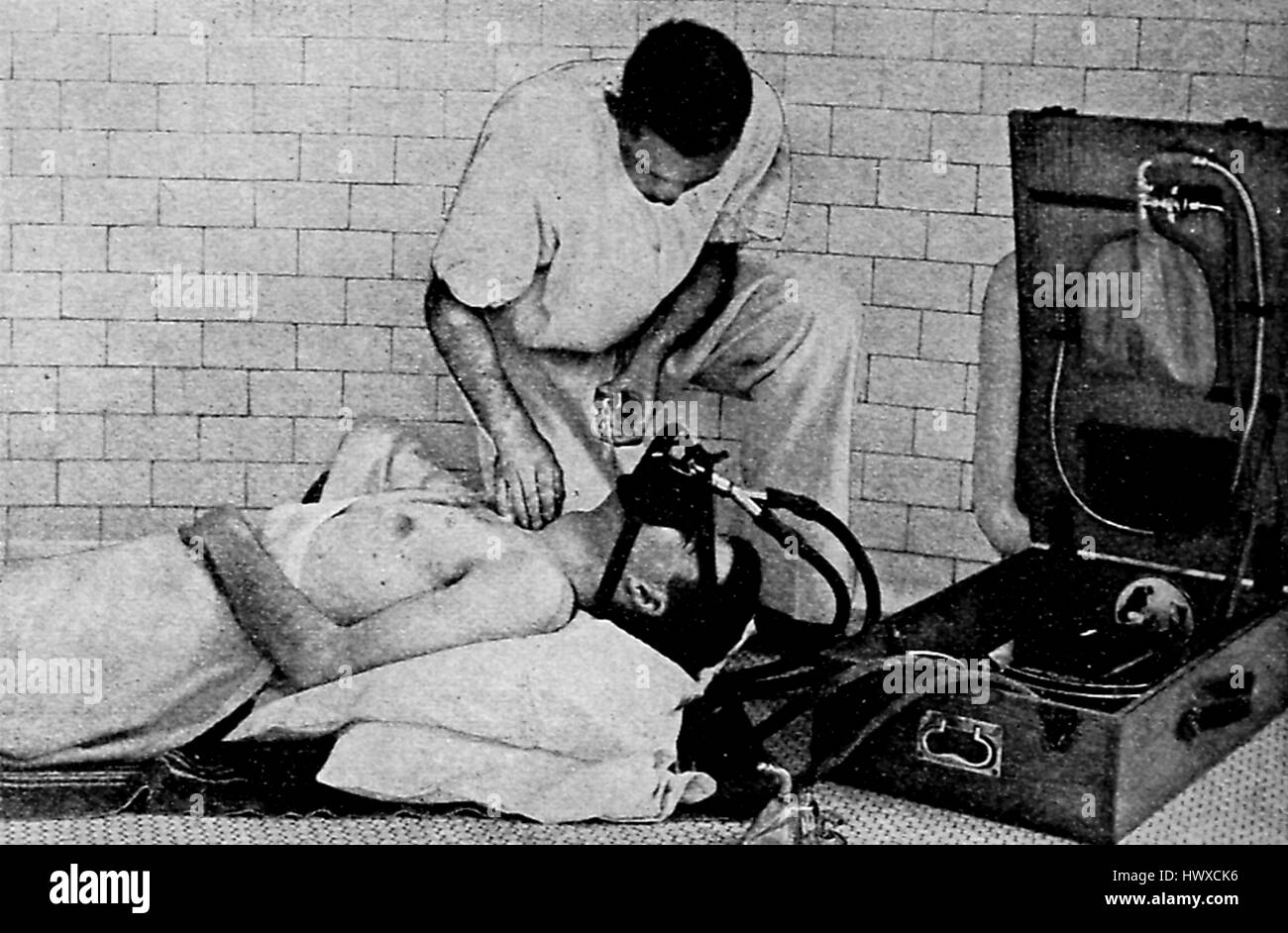 Illustrazione dell'utilizzo di un inizio di ventilatore che utilizzata una maschera ad ossigeno per ripristinare le vittime di anestesia, avvelenamento da gas velenosi, inalazione di fumo, annegamento o elettrocuzione, 1916. Foto Stock