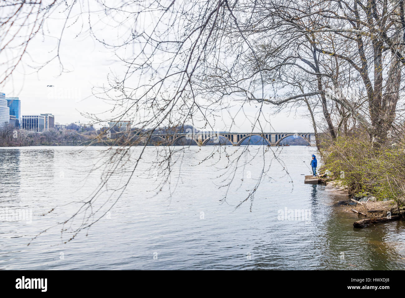 Washington DC, Stati Uniti d'America - 20 Marzo 2017: persone di pesca sul lungofiume di Georgetown con chiave ponte nel fiume Potomac Foto Stock