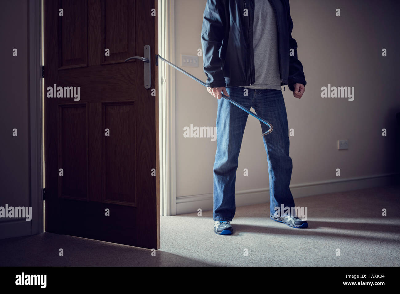 Ladro di commettere un furto con scasso la criminalità in una casa con un palanchino Foto Stock