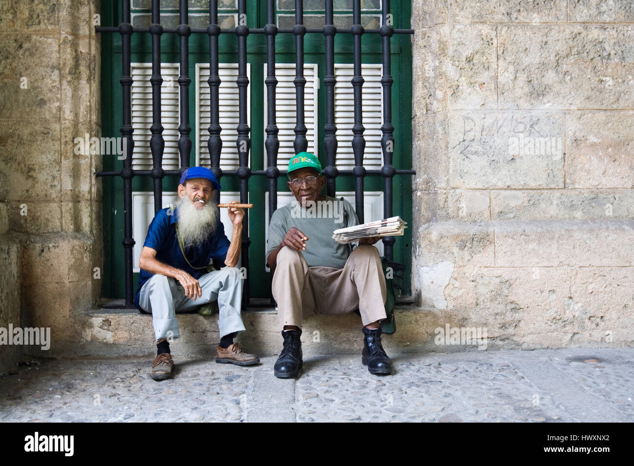 Due sigarette fumatori uomo e uno tenendo un sigaro in mano, Cuba. Foto Stock