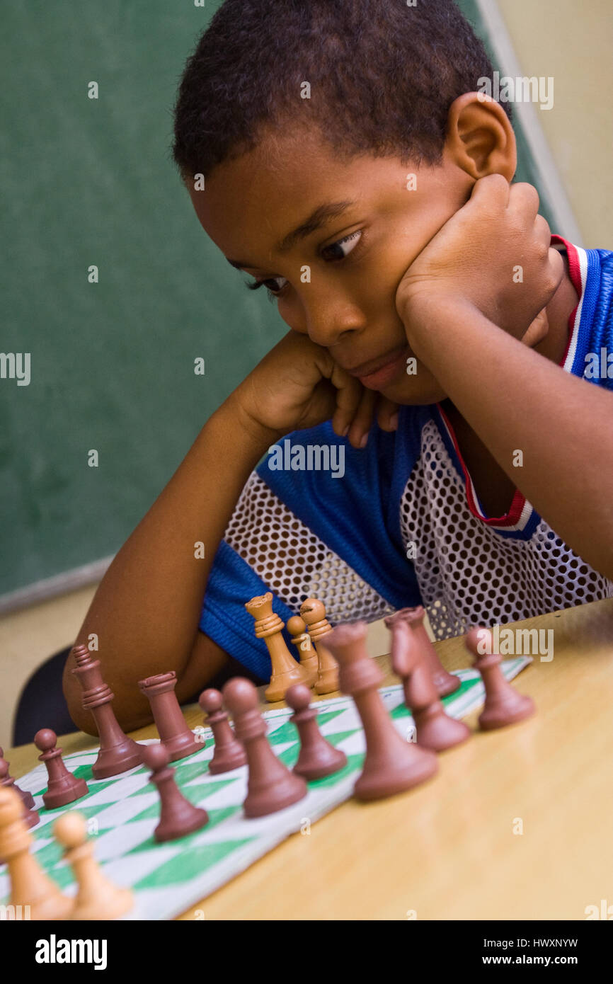 Giovane ragazzo giocando a scacchi, Cuba. Foto Stock