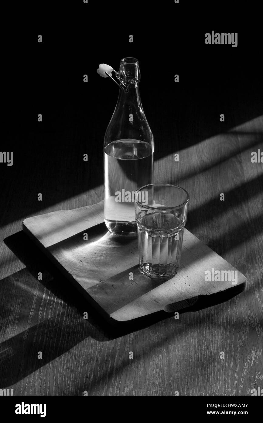 Una bottiglia di acqua minerale e un bicchiere. Foto Stock