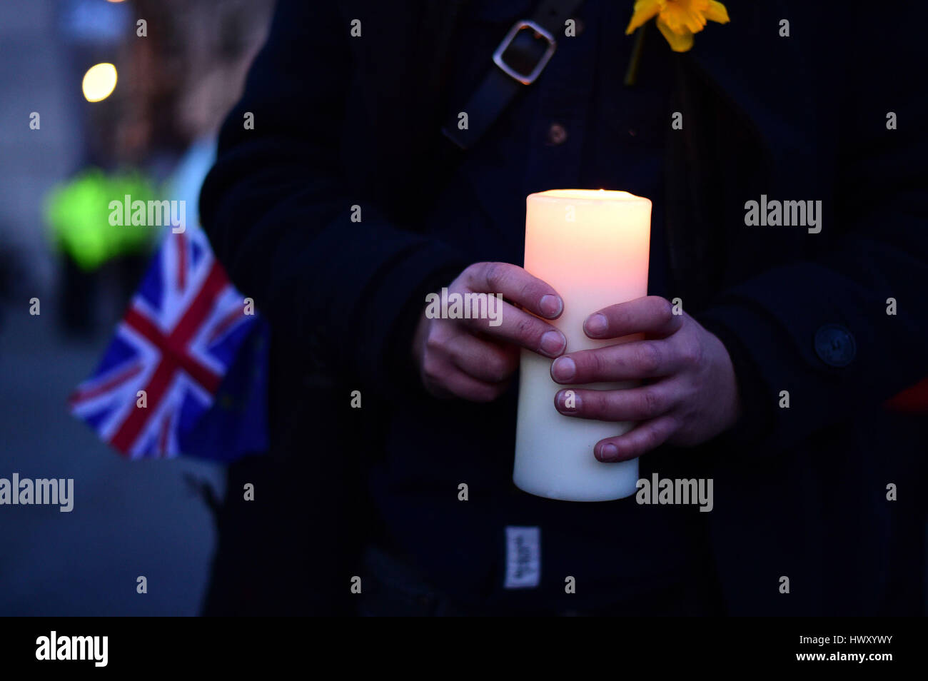 Un membro del pubblico detiene una candela durante la veglia a lume di candela in Trafalgar Square, Londra per ricordare coloro che hanno perso la vita nella Westminster attacco terroristico. Foto Stock