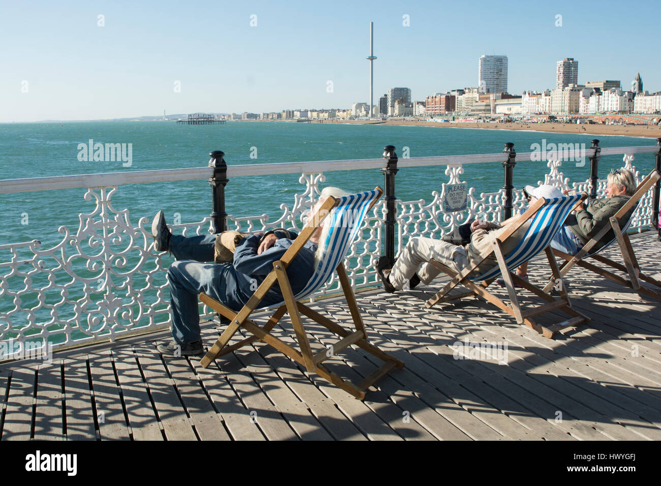 I pensionati sono rilassanti al sole su Brighton Peer. Foto Stock