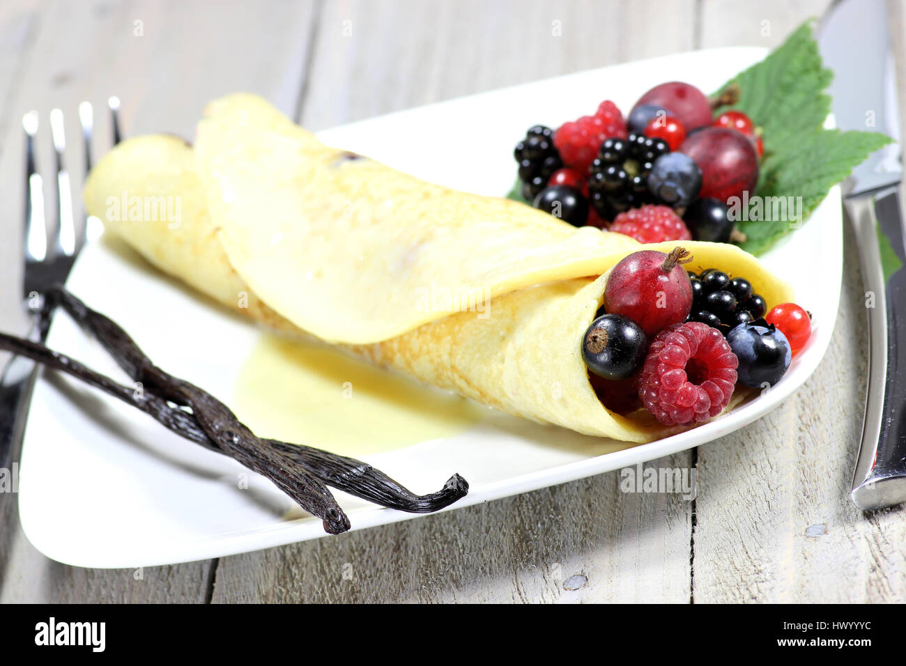 Pancake con giardino bacche e salsa di crema pasticcera Foto Stock