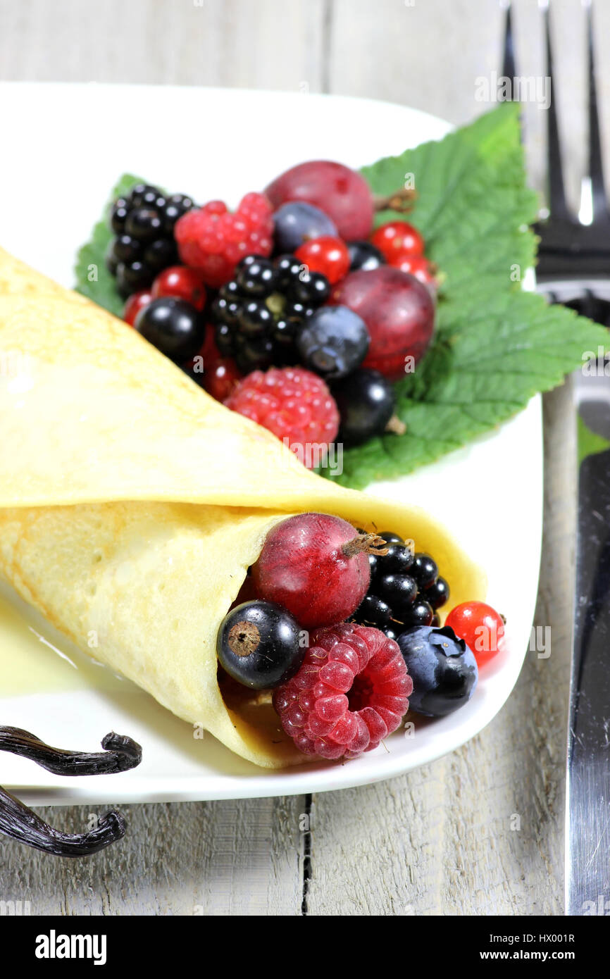 Pancake con giardino bacche e salsa di crema pasticcera Foto Stock