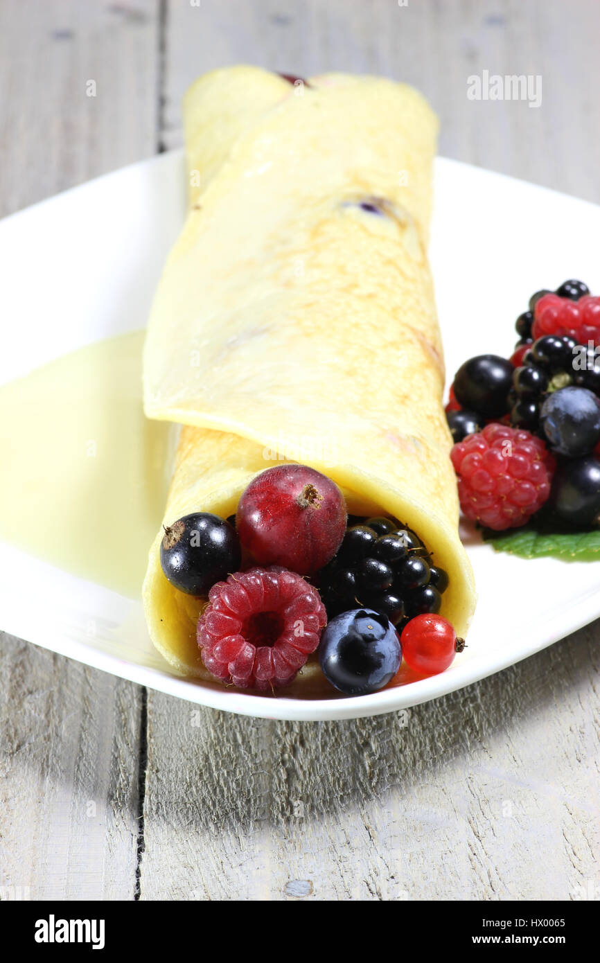 Pancake con giardino bacche e salsa di crema pasticcera Foto Stock