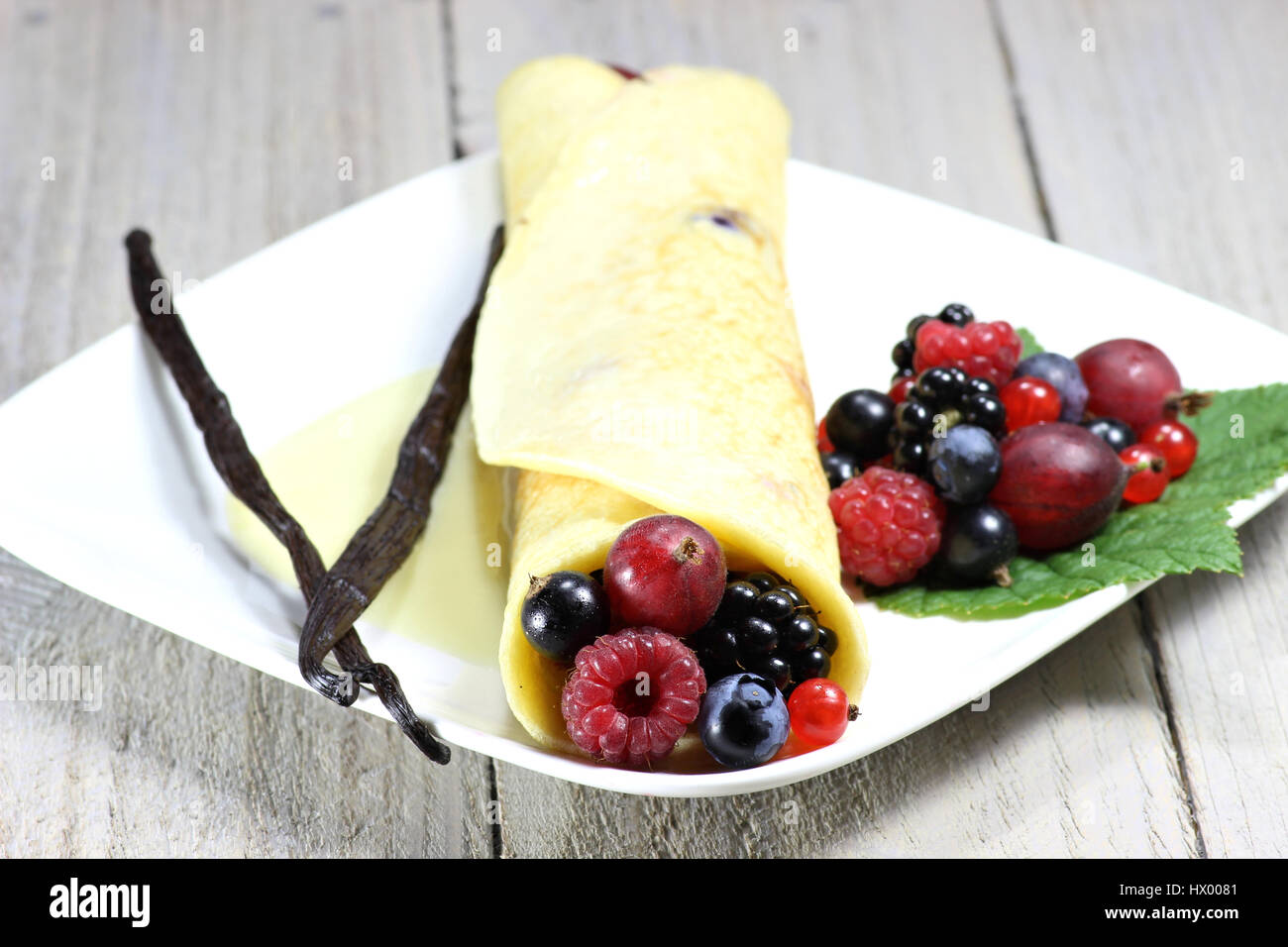 Pancake con giardino bacche e salsa di crema pasticcera Foto Stock