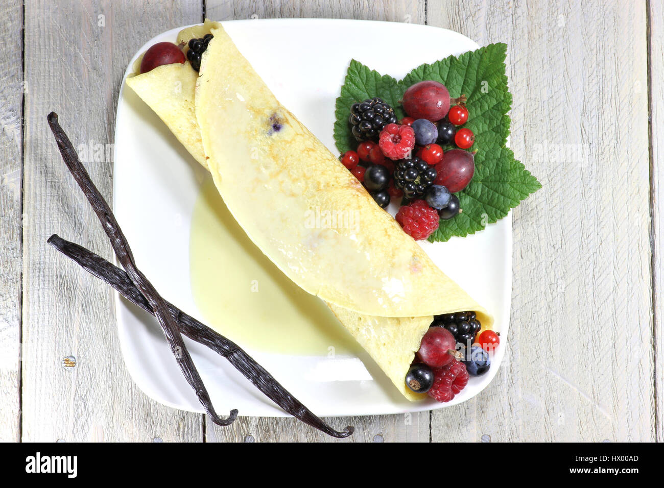 Pancake con giardino bacche e salsa di crema pasticcera Foto Stock