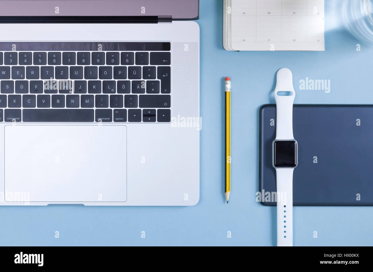 Vari dispositivi elettronici, agenda elettronica personale e una matita sulla massa blu Foto Stock