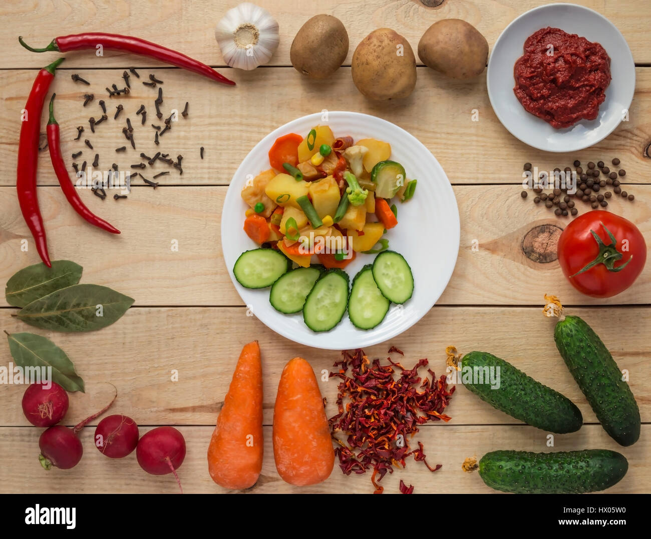 Stufato di vegetali (patate, asparagi, carote, i cavoli di Bruxelles, mais, piselli, cavolo verza, broccoli) in una piastra bianca. Vegane. Foto Stock