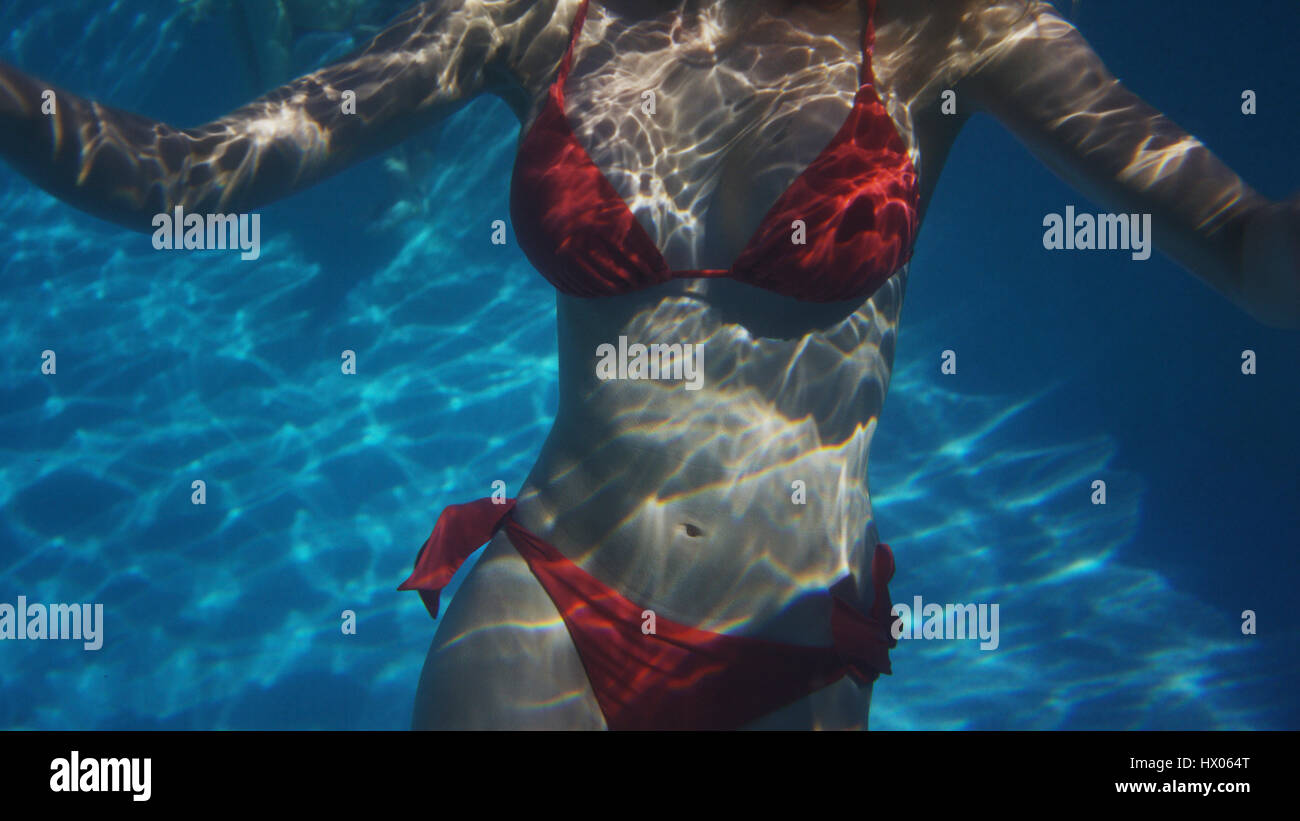 Vista subacquea della donna in bikini nuoto in piscina Foto Stock
