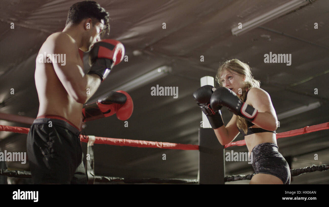 Basso angolo di visione del boxer di punzonatura e combattimenti nel pugilato ring durante il match Foto Stock