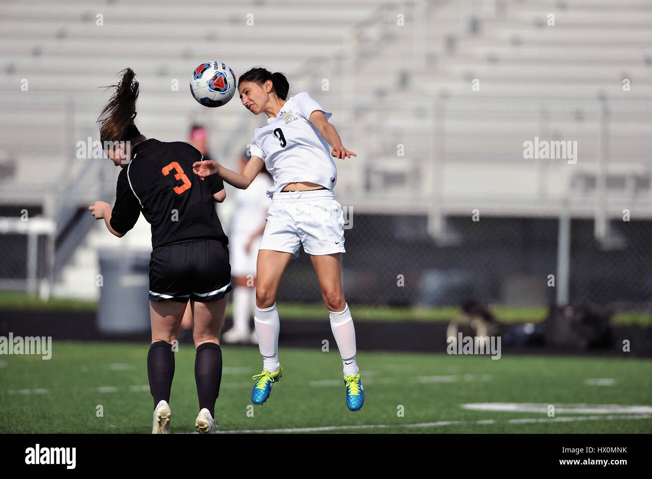 High school player tenta la testata durante il confronto competitivo. Foto Stock