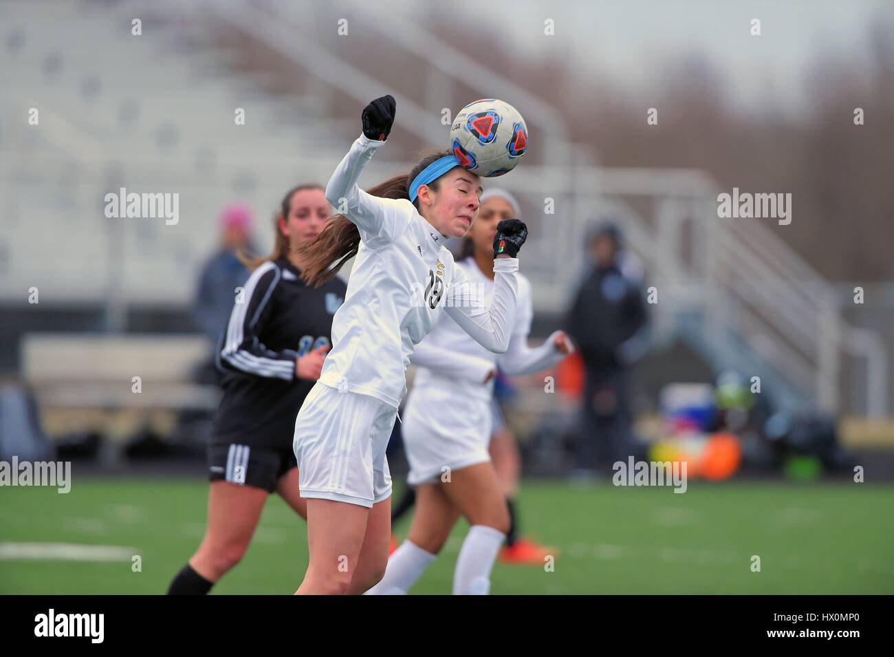 High school player tenta la testata durante il confronto competitivo. Foto Stock