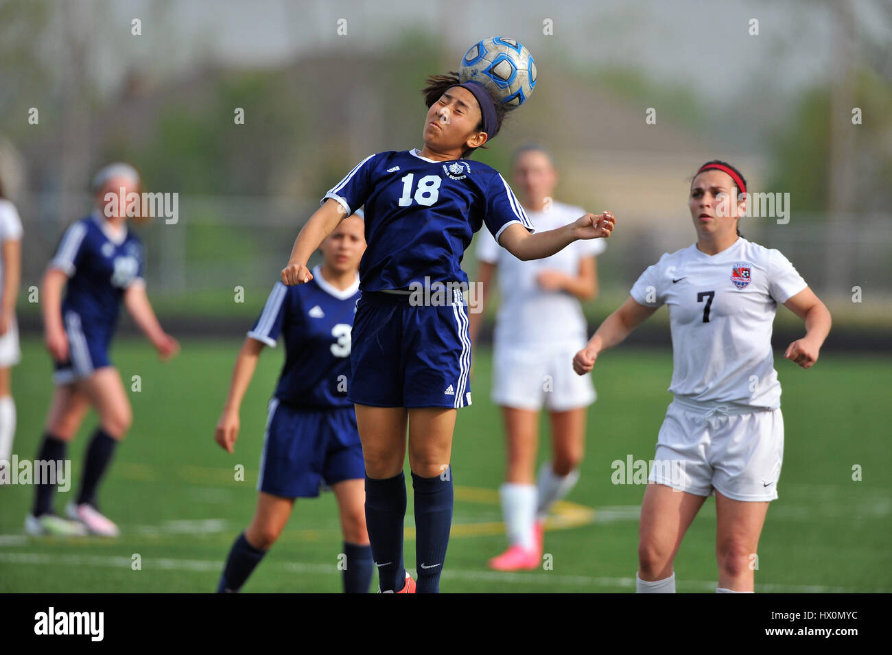 High school player tenta la testata durante il confronto competitivo. Foto Stock