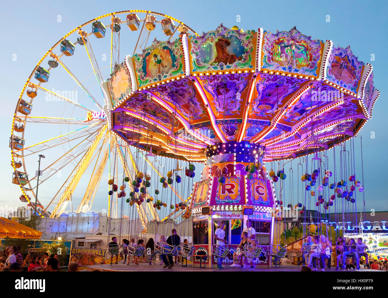 Illuminato giostra oscillante e la ruota panoramica Ferris, Cranger Kirmes, il più grande festival folk nel distretto della Ruhr, Herne Foto Stock