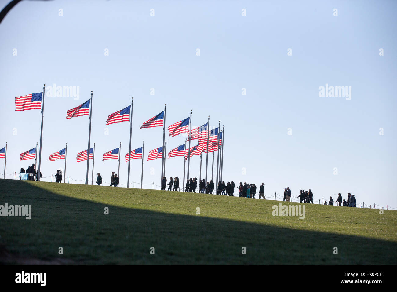 I turisti si avvicinano al Monumento di Washington sul National Mall di Washington, D.C. Marzo 22, 2017. Foto Stock