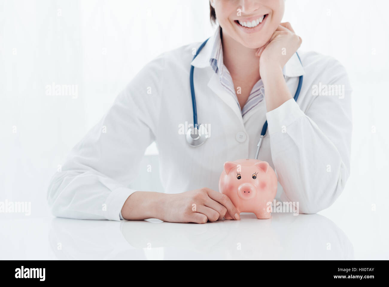 Medico donna e salvadanaio: salute assicurazioni, spese mediche e di concetto fiscale Foto Stock