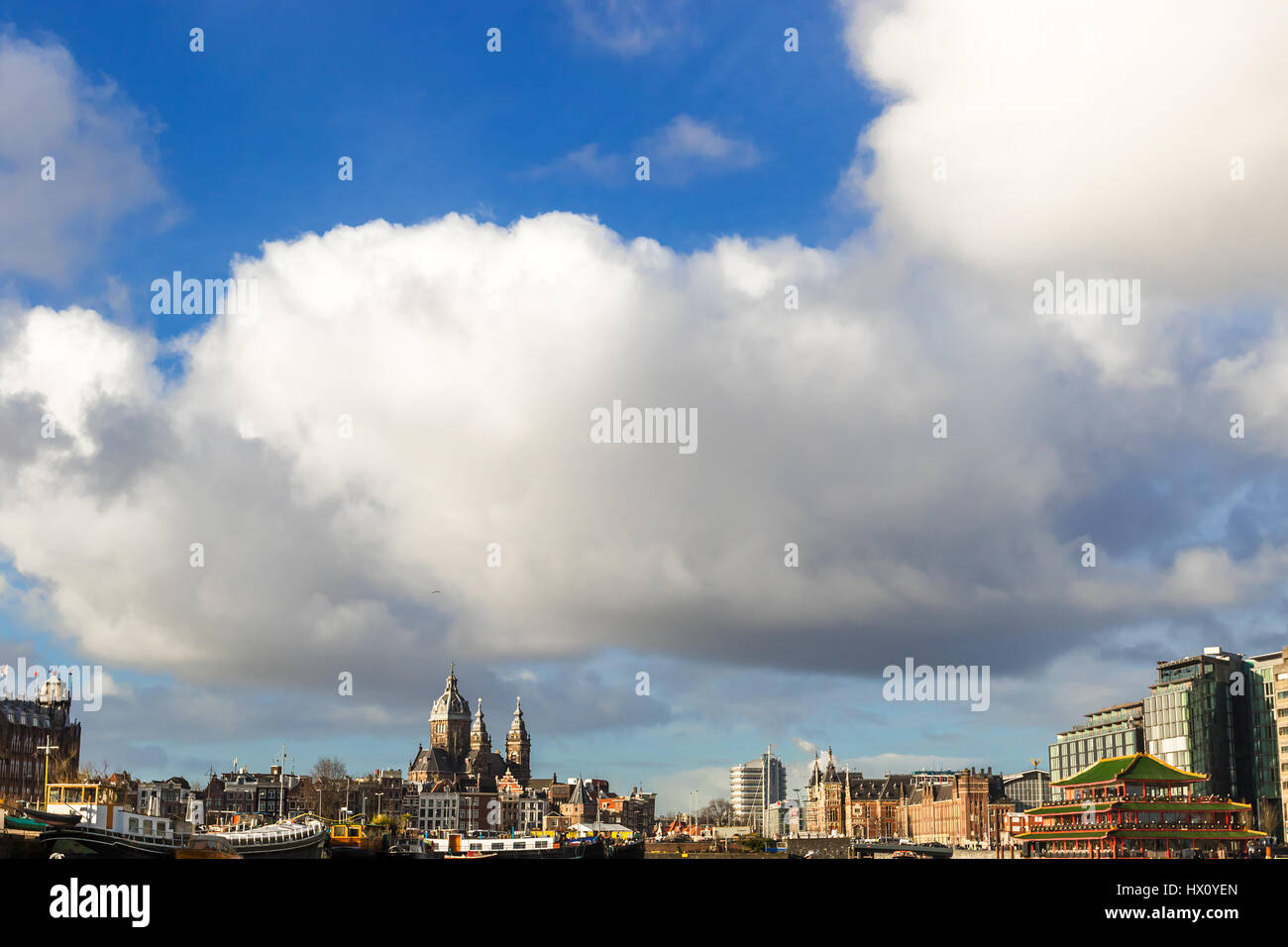 Bella vista dei canali di Amsterdam con ponti e le tipiche case fiamminga nel tempo molto soleggiato con cielo blu. Foto Stock