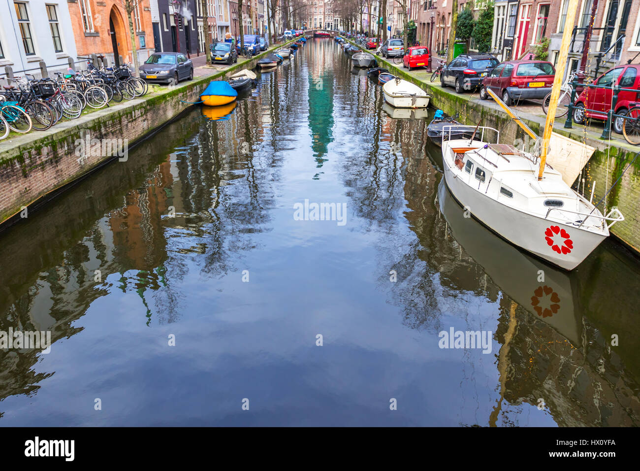 Bella vista dei canali di Amsterdam con ponti e le tipiche case fiamminga nel tempo molto soleggiato con cielo blu. Foto Stock