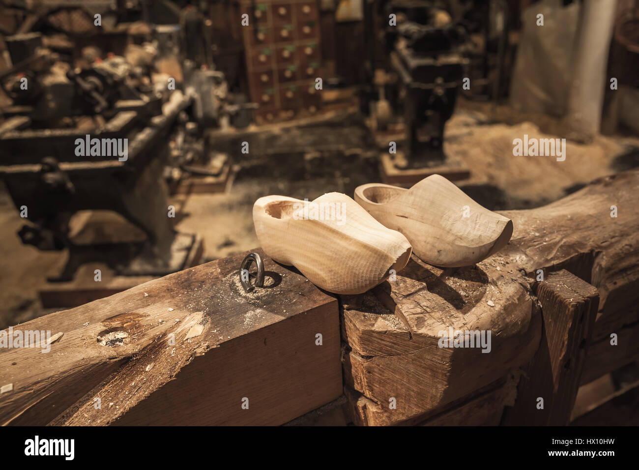 Coppia di zoccoli realizzati in legno di pioppo. Klompen, tradizionale olandese di calzature per uso quotidiano stare sulla trave di legno in stabilimento di produzione Foto Stock
