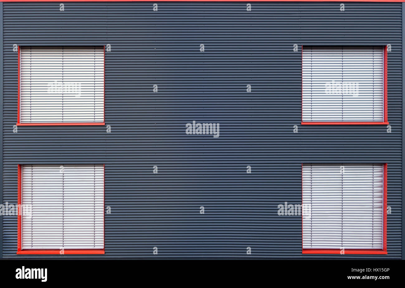 Blu di ferro ondulato facciata con quattro finestre chiuse Foto Stock
