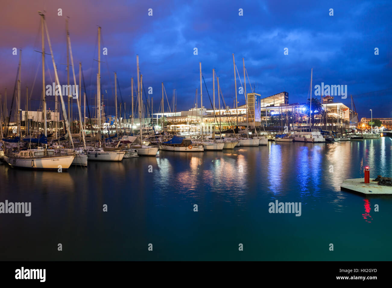 Port Vell marina al crepuscolo in Barcelona city, barche a vela e yacht e il centro commerciale Maremagnum, Catalogna, Spagna Foto Stock