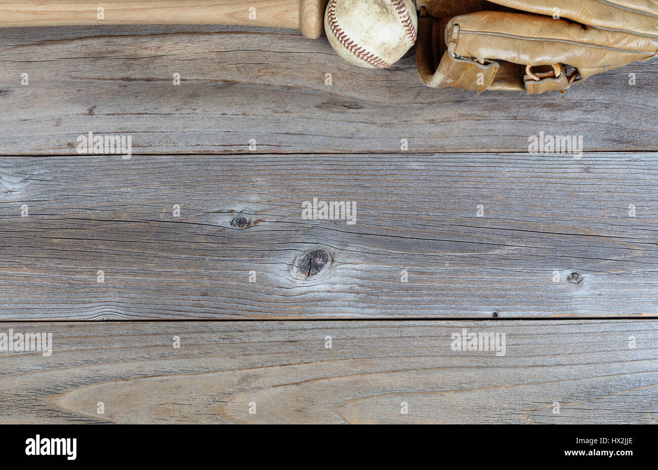 Vista aerea di un bordo superiore di una parziale utilizzata attrezzatura da baseball su legno rustico Foto Stock