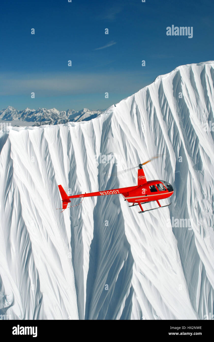 Aria-aria ritratto di un rosso Robinson R44 Clipper elicottero sopra la Chugach Mountains in Alsaka. Foto Stock