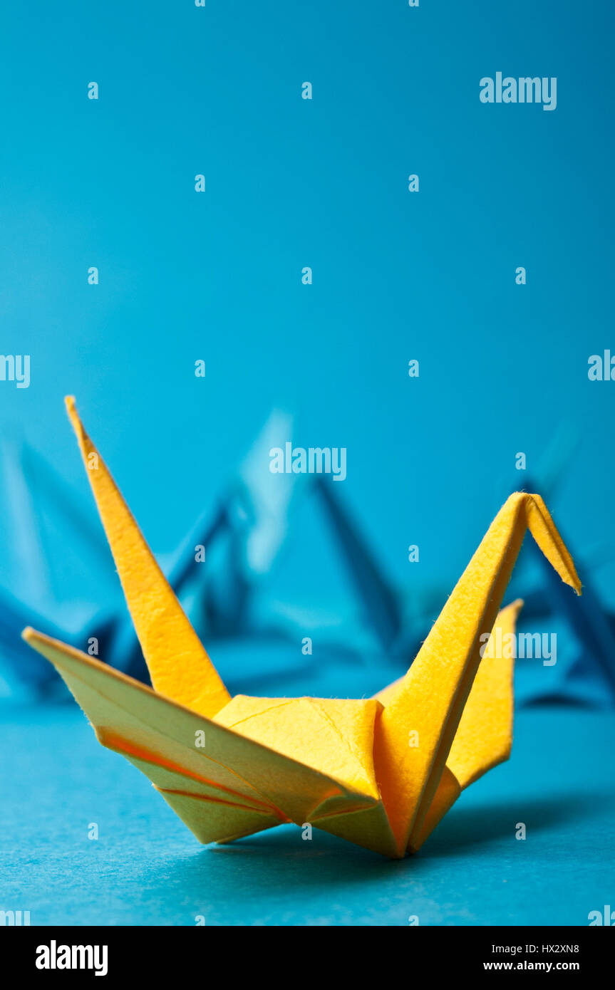Origami uccello giallo tra quelli blu, unicità concept Foto Stock