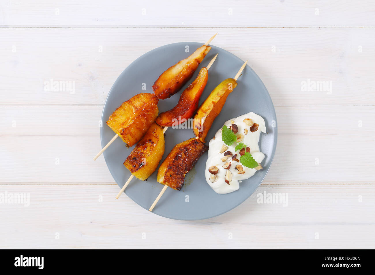 Piastra della pera e arancia spiedini con yogurt, noci tritate e mandorle Foto Stock