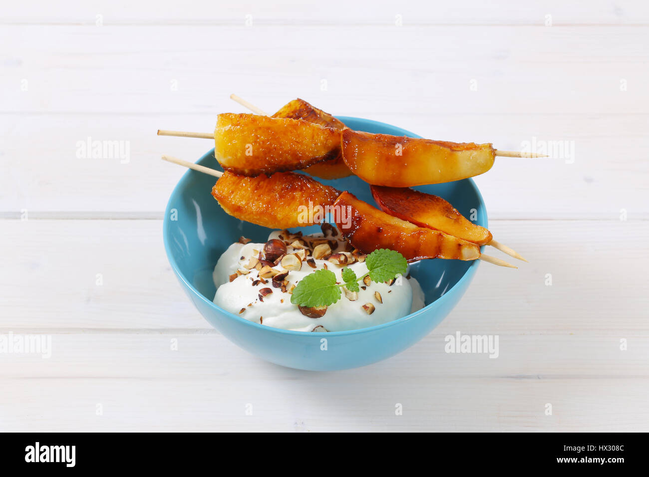 Ciotola di pera e arancia spiedini con yogurt, noci tritate e mandorle Foto Stock