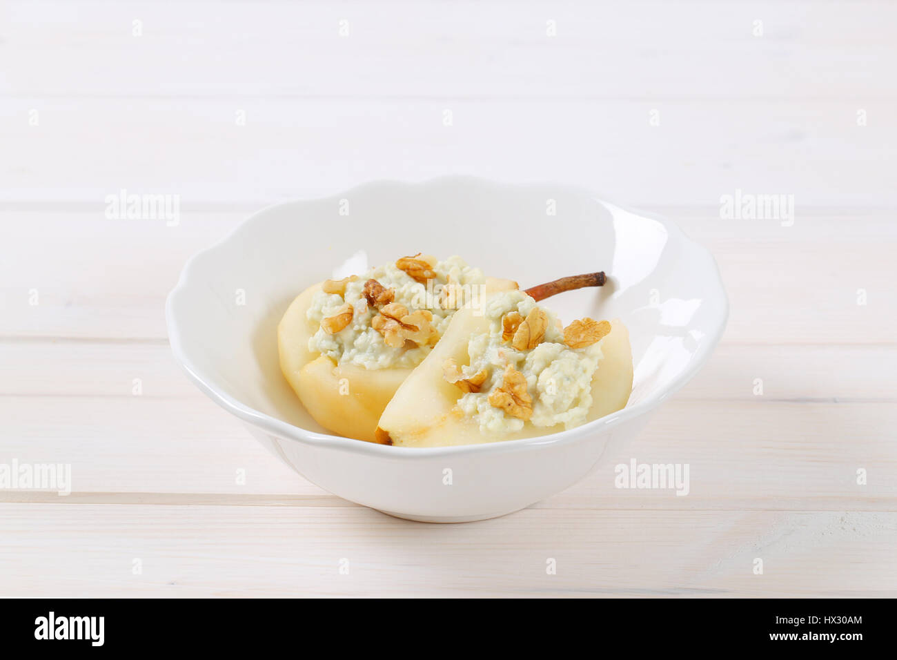 Ciotola di dimezzato di pere con gorgonzola e noci su sfondo bianco Foto Stock