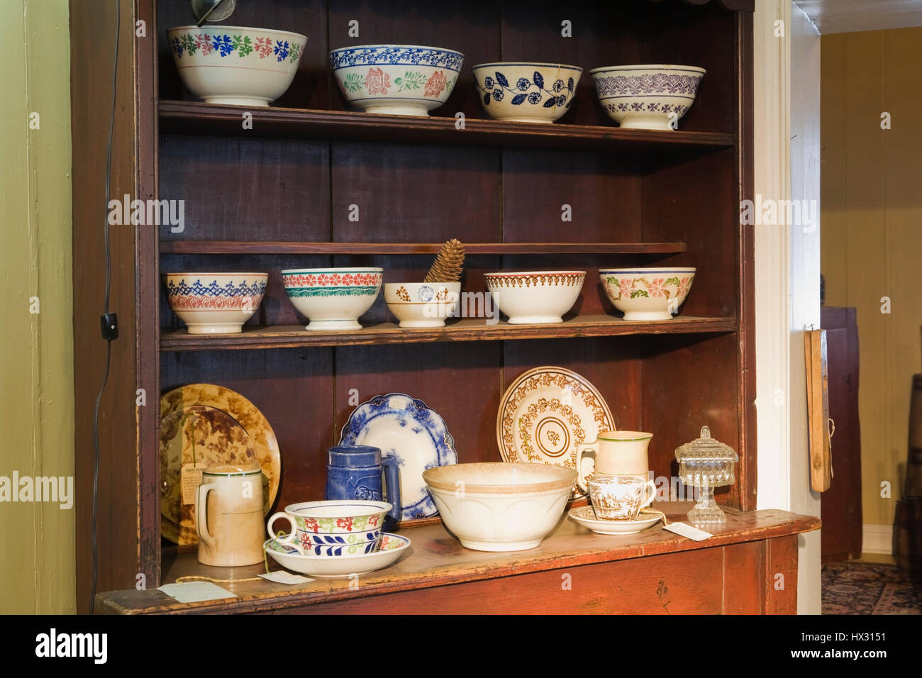 Buffet marrone di legno antico con stoviglie e porcellana in un negozio di antiquariato situato all'interno di 1810 casa vecchia. Foto Stock