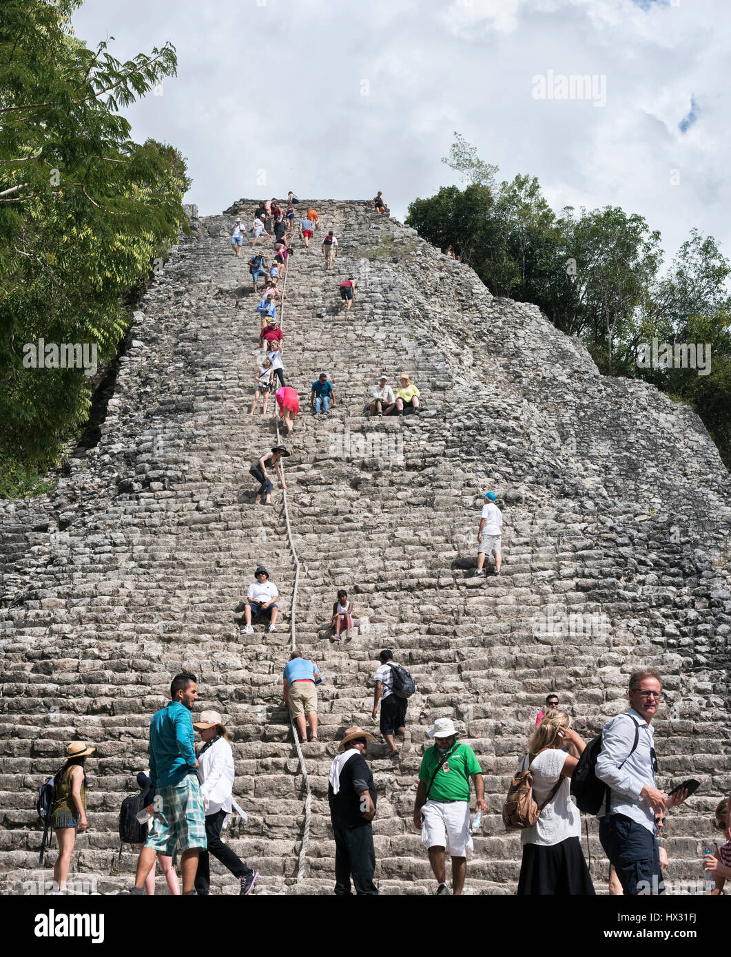 I turisti a piramide Nohoch Mul dei Maya di Coba rovine, Messico Foto Stock