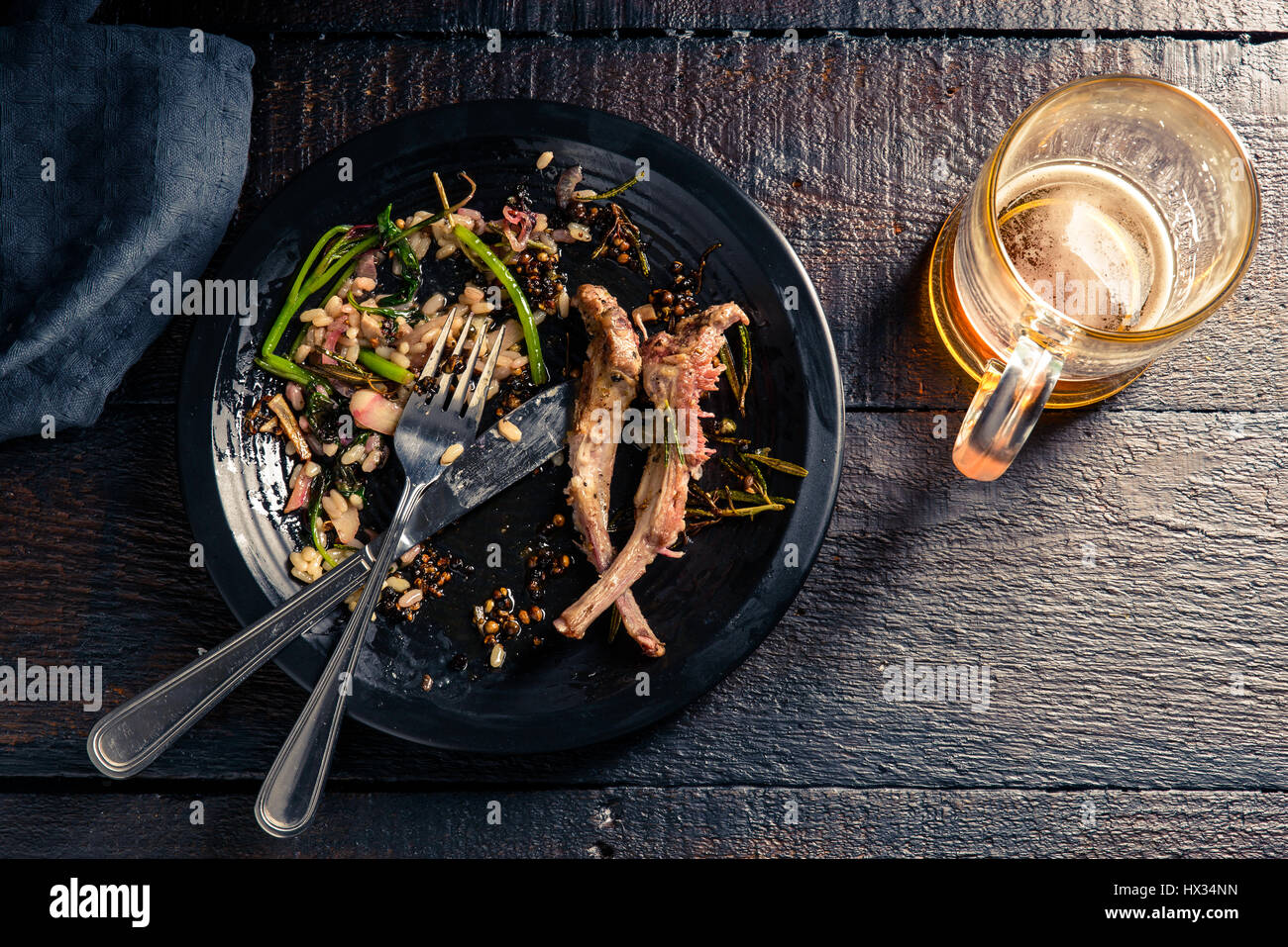 Semi-mangiato condito costolette di agnello con risotto ai funghi e rosso cinese di spinaci Foto Stock