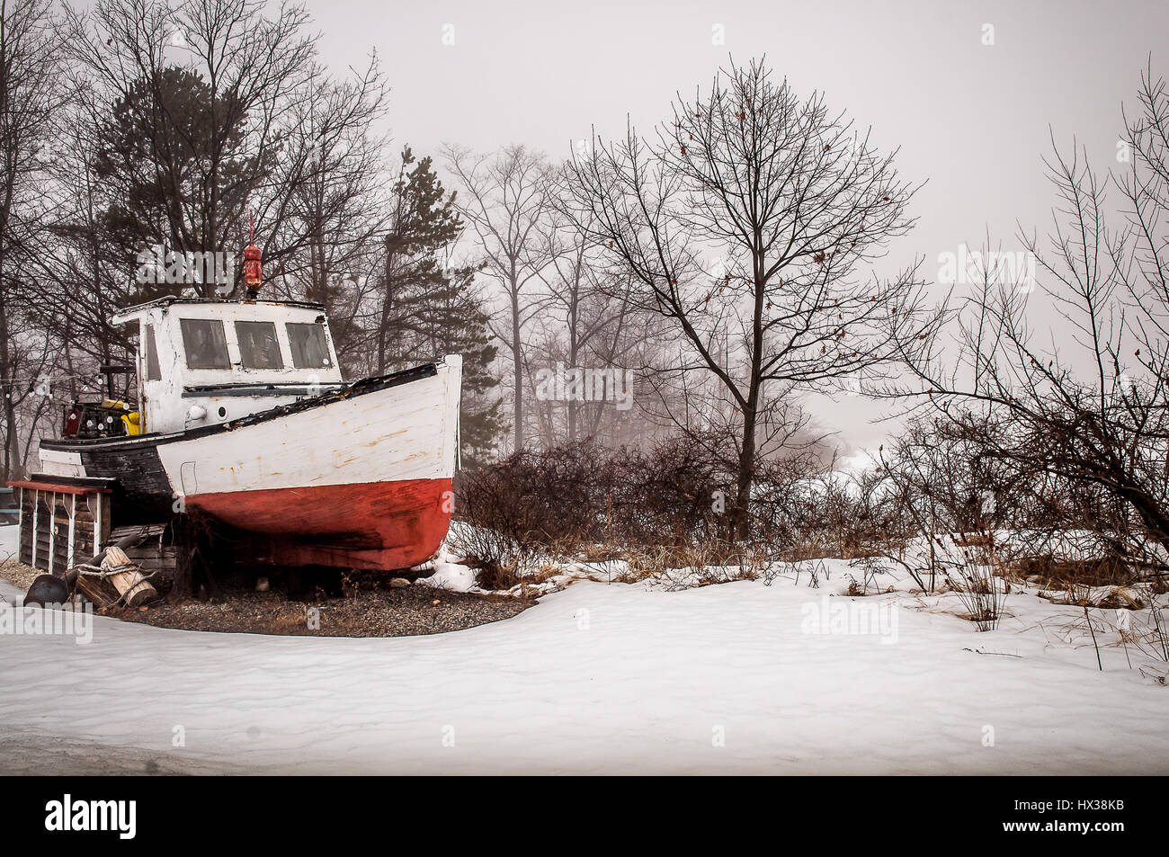 Questo vecchio lobster boat è in riparazione, come la nebbia comincia a rotolare in dall'oceano. In inverno il clima cambia rapidamente. Così le riparazioni devono essere eseguite velocemente Foto Stock