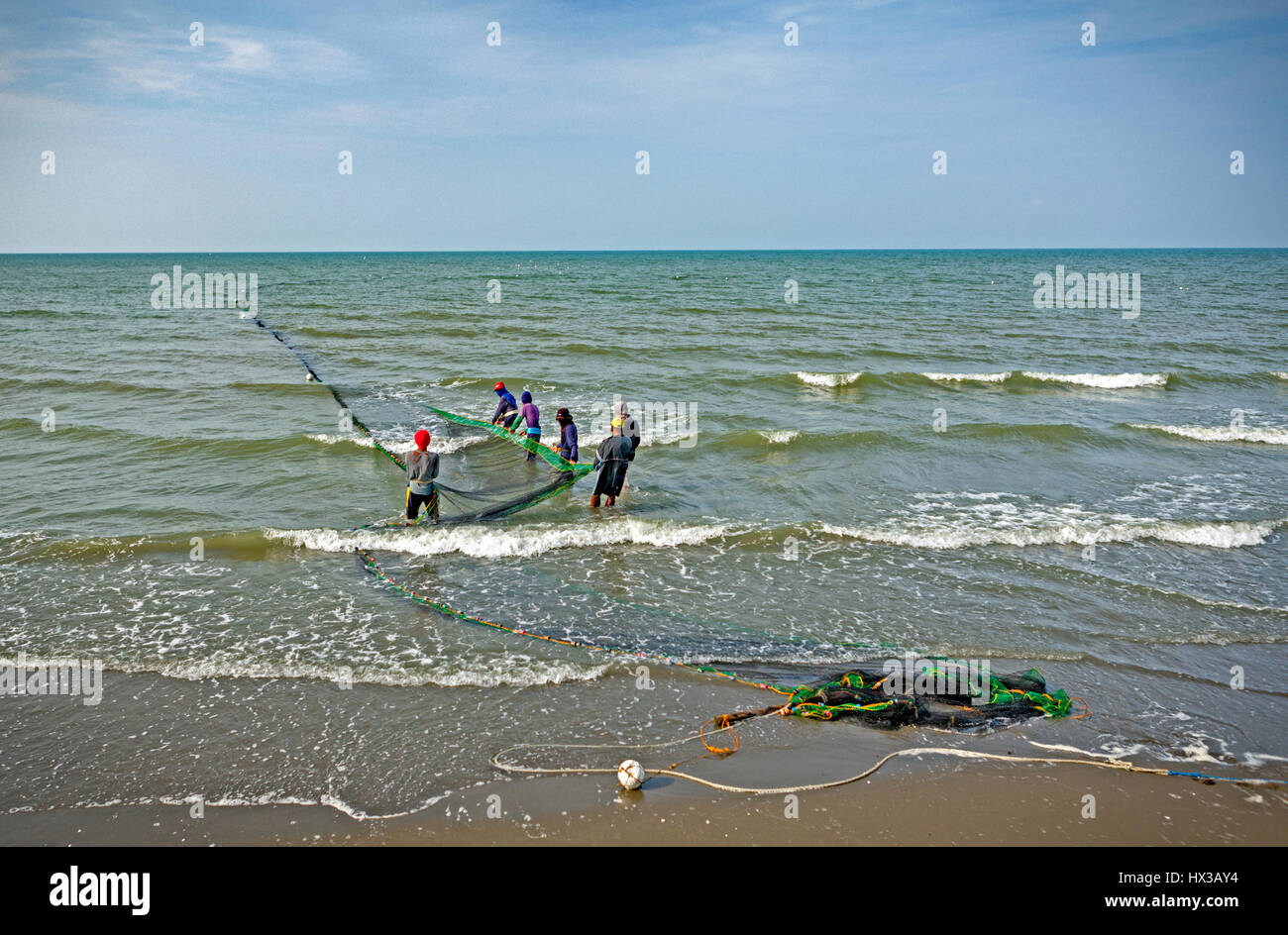 Sei uomini filippini lavorano insieme tirando la loro enorme seine net a shore a Baybay Beach, Roxas City, Panay Island, Filippine. Questi pescatori appartengono a Foto Stock