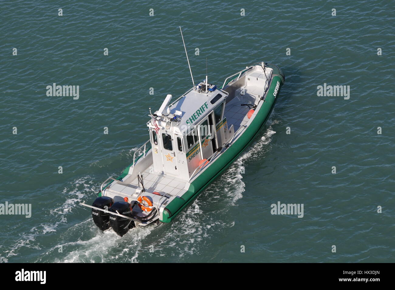 Un basso fotografia aerea di uno sceriffo del Dipartimento imbarcazione di pattuglia un americano di porto. Foto Stock