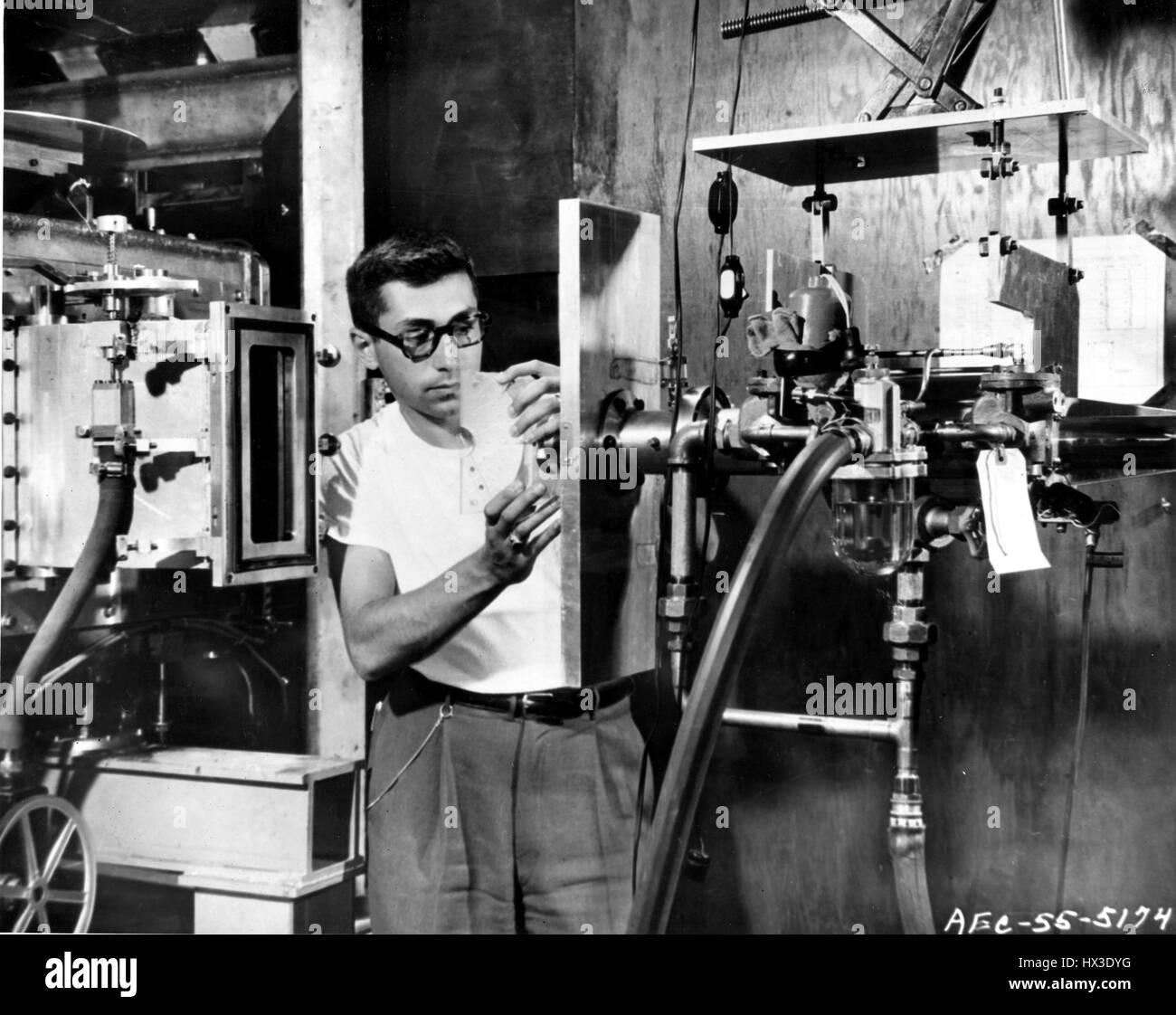 Un fisico si prepara un pezzo di plastica che verrà bombardato con miliardi di volt protoni nel Cosmotron a Brookhaven National Laboratory di Upton, New York, 1955. Immagine cortesia del Dipartimento Americano di Energia. Foto Stock