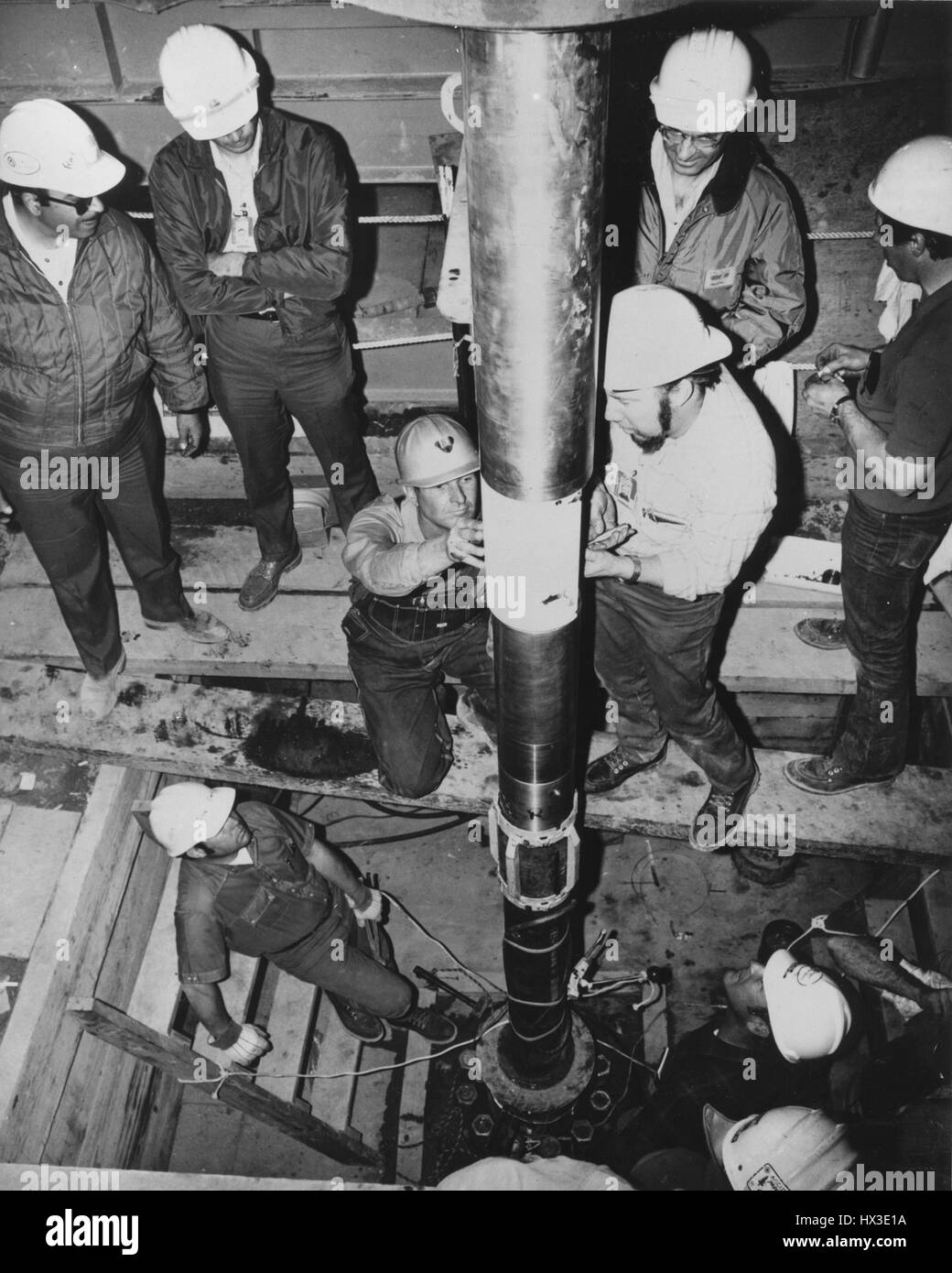Un tecnico meccanico (al centro a destra) collega un blindato esterno cavo di tiro per la seconda delle tre 30-kiloton esplosivi nucleari per essere utilizzato nella giunzione di governo-industry Project Rio Blanco, Rio Blanco County, Colorado, 1973. Immagine cortesia del Dipartimento Americano di Energia. Foto Stock