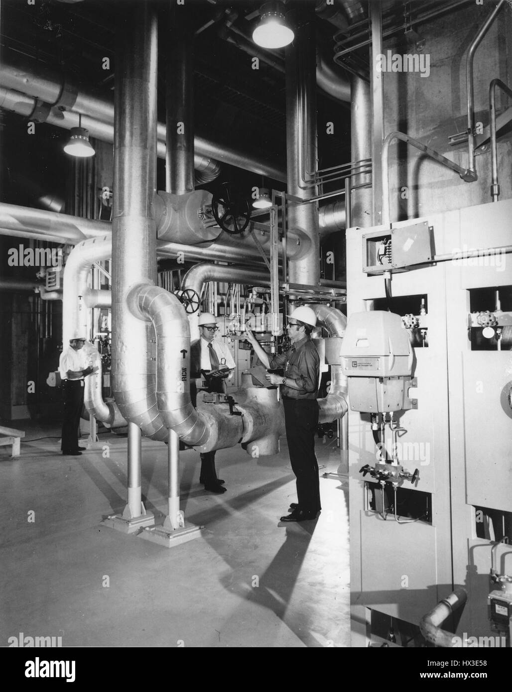 Ispettori governativi con il Dipartimento dell'Energia controllo condotti aria sul grezzo di un sistema di raffreddamento ad acqua nel Tennessee Valley Authority di Browns Ferry unità 1 impianto nucleare, Decatur, Alabama, 1973. Immagine cortesia del Dipartimento Americano di Energia. Foto Stock