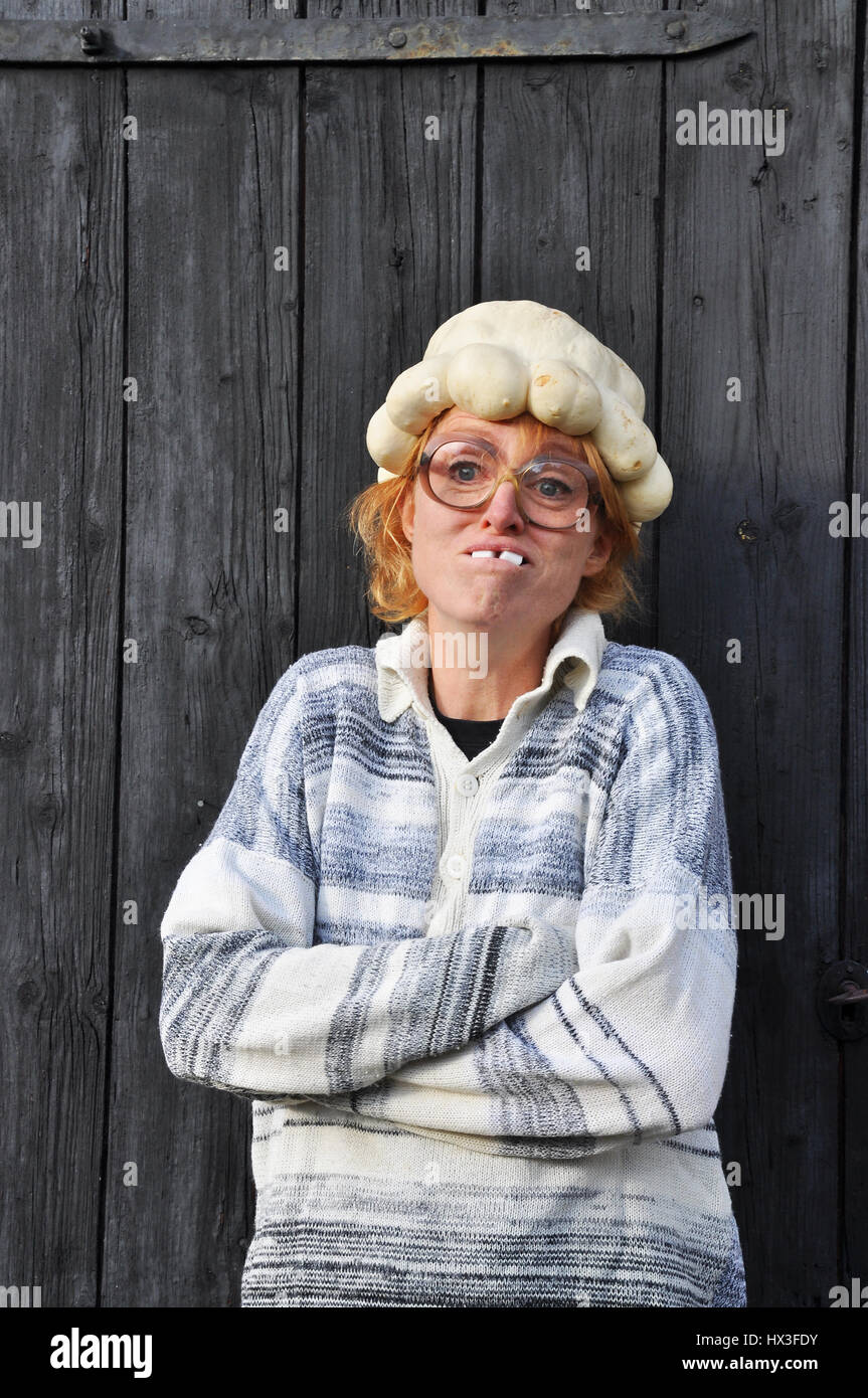 Donna divertente con la zucca come un cappello. Foto Stock