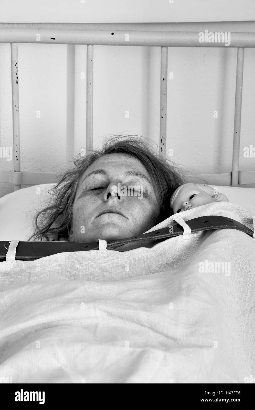 Donna con bambola legata a letto in un reparto psichiatrico Foto stock -  Alamy