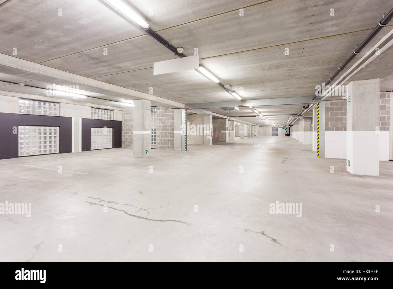 Parcheggio sotterraneo di un centro commerciale con colonne e condotti di ventilazione Foto Stock