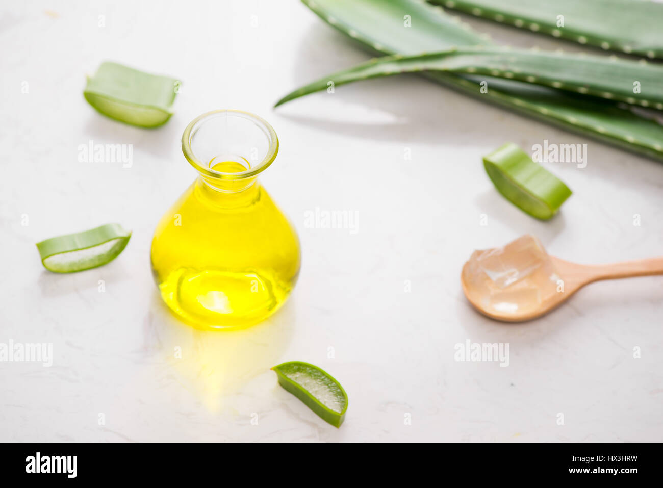 Aloe vera olio essenziale e Aloe foglie su uno sfondo bianco. Foto Stock