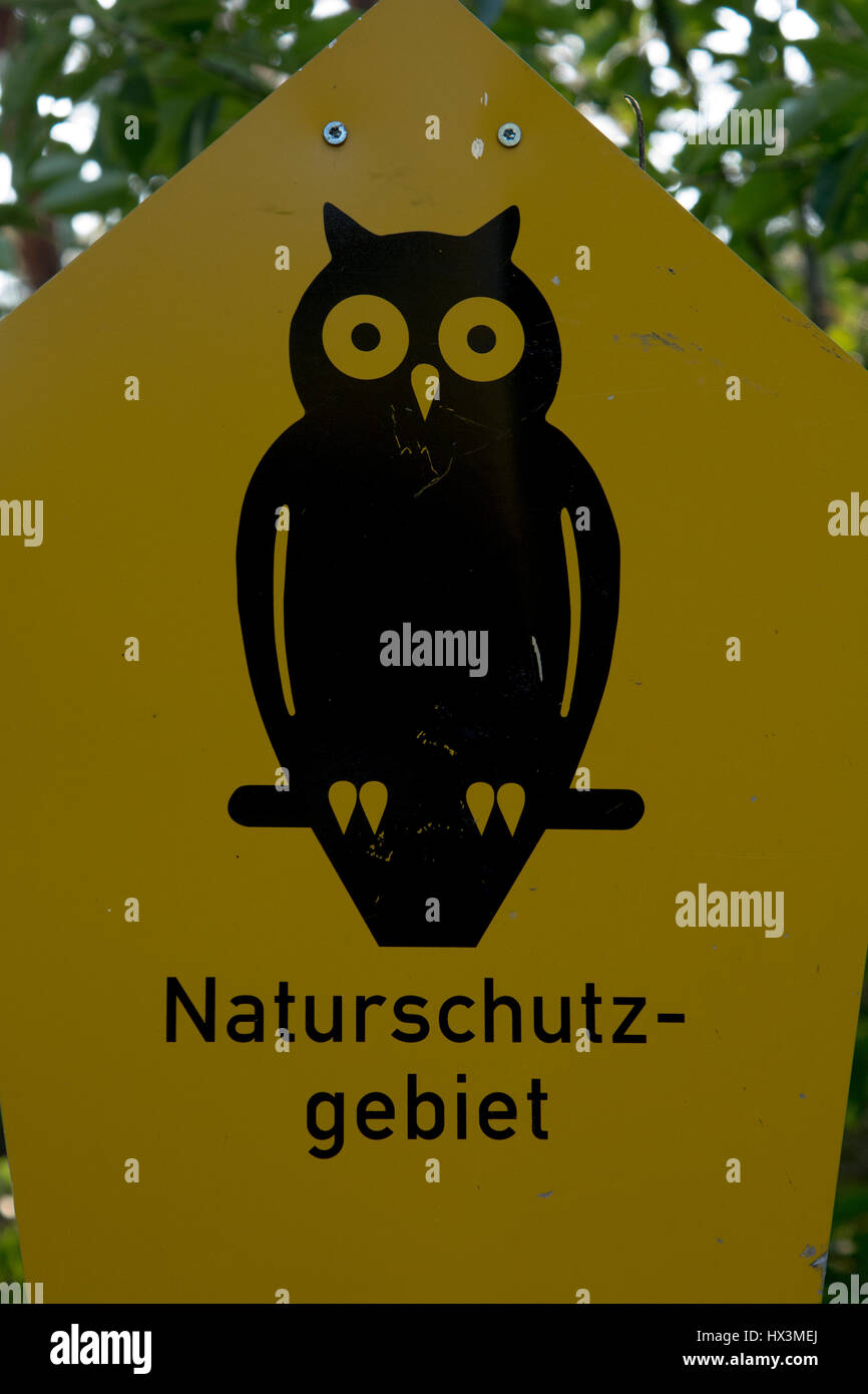 Un gufo nero su un pentagono giallo è il segno nazionale per le riserve naturali in Germania. Ein Schild mit einer schwarzen Eule auf einem gelben Pentagono w Foto Stock