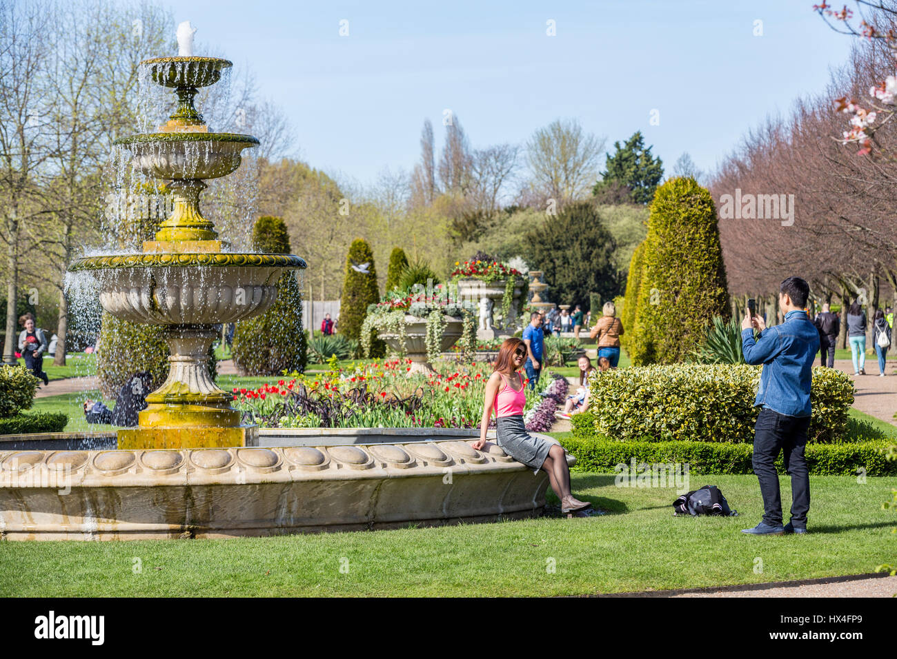 Il Regents Park, Londra, bagna nel caldo sole primaverile, portando fuori i londinesi e turisti tenendo selfies con il loro smartphone, Londra Inghilterra REGNO UNITO Foto Stock